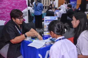 Sekolah Victory Plus students engage with a university representative at the University Fair, learning about academic programs.