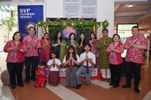 Parents, teachers, and school leaders posing together in front of Diwali decorations at Sekolah Victory Plus.