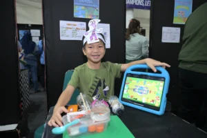 A student of Sekolah Victory Plus, an international school in Bekasi, showcasing his masterpiece from recycled trash during the learning celebration.