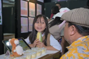 A Grade 3 student of Sekolah Victory Plus Bekasi, an international school in Indonesia, explained her project to a teacher during the learning celebration.