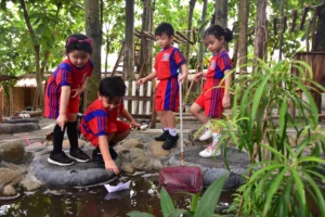 Siswa-siswi Sekolah Victory Plus, sekolah internasional terbaik, bermain dan belajar dengan mengeksplor area luar ruang.