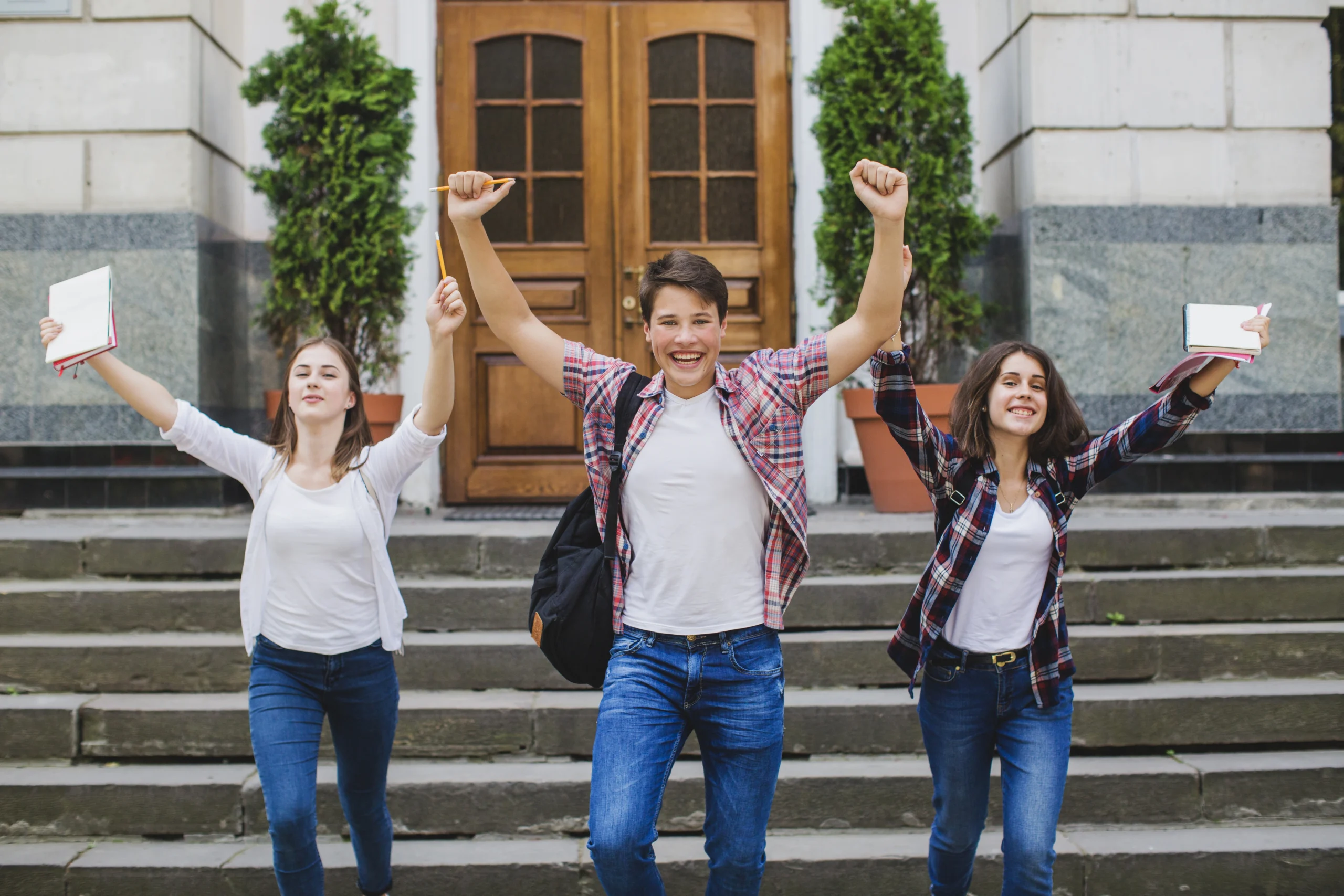 young people looking victorious standing in front of their campus