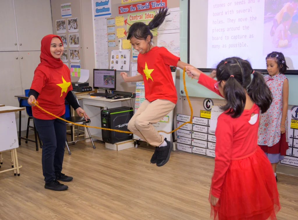 Students and a teacher of Sekolah Victory Plus, an IB school near Jakarta, playing a traditional game during the United Nations Day Celebration.